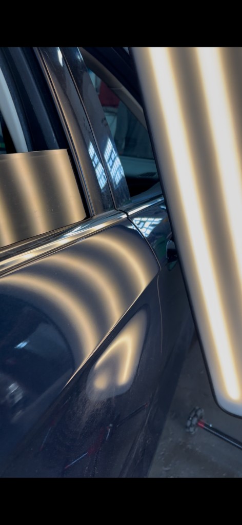 After PDR: dark blue car door, dent removed, glossy factory finish
